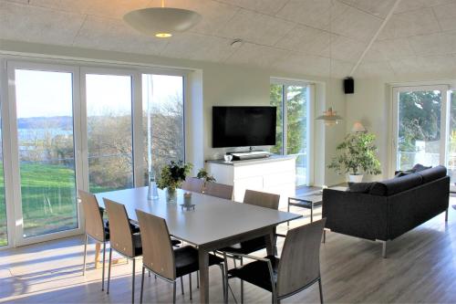 a dining room with a table and chairs and a television at Naturperlen in Rødekro