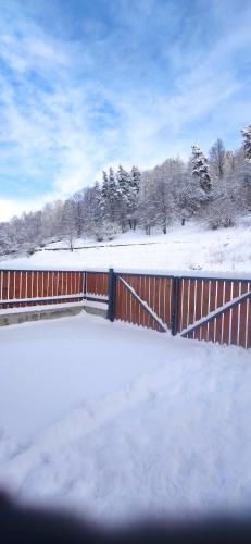 a fence covered in snow next to a snow covered field at Villa Bayern in Bakuriani in Bakuriani