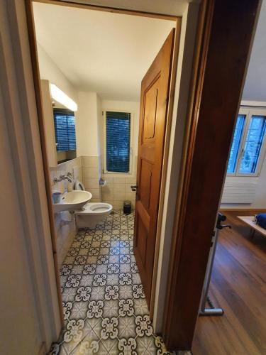 a bathroom with a toilet and a sink and a door at Traditional Swiss-Flat in Interlaken