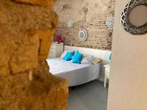 une chambre avec un lit avec des oreillers bleus dans l'établissement La Herrería de Sagasta, à Cadix