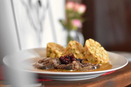 a plate of food with meat and waffles on a table at Hotel Petřín in Jablonec nad Nisou