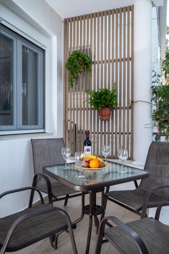 a table with a bowl of fruit and wine glasses at Spacious & Luxe 3BR Downtown 1min to Beach in Kos