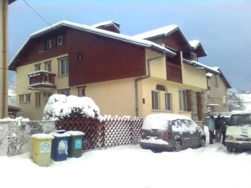 a house with a car parked in the snow at Hotel Four Seasons in Samokov