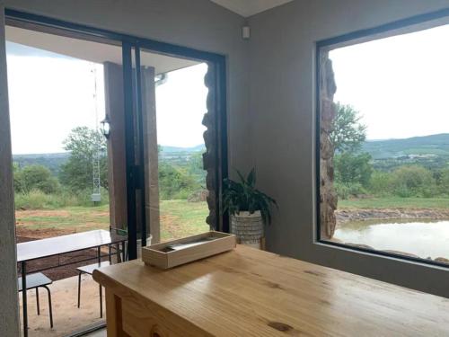 a room with a wooden table and a large window at Hazyview Accommodation, Bon Repose Cottage 1 in Hazyview