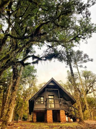 a house in the woods with a balcony at Oásis Pousada in Cambará