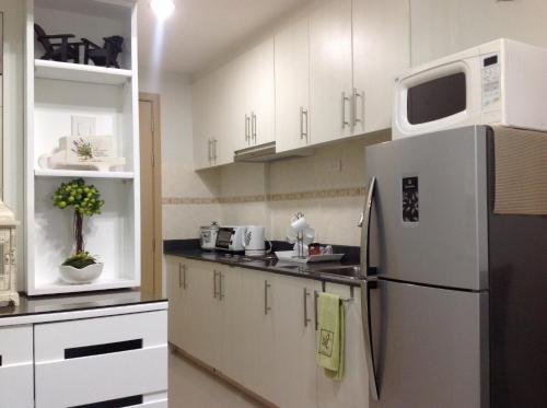 a kitchen with a refrigerator and a microwave at Sea Residences MoA Manila in Manila