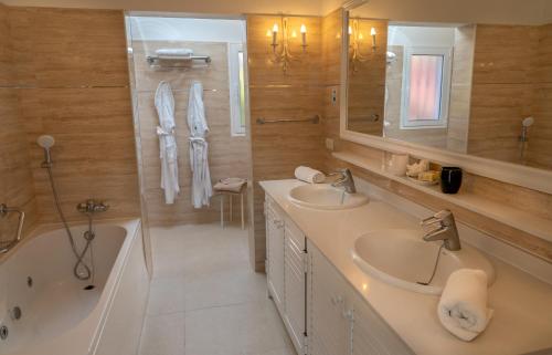 a bathroom with two sinks and a bath tub and a tubermott at La Palma Jardín Resort in El Paso