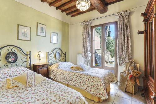 a bedroom with two beds and a window at Villa Sunshine in Gambassi Terme