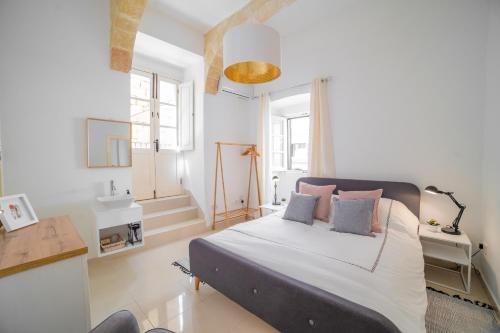 ein Schlafzimmer mit einem Bett mit zwei Kissen darauf in der Unterkunft Carmelita Maisonette Valletta in Valletta