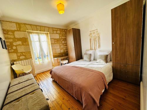 a bedroom with a large bed and a window at Domaine des Hugons in Prignac-et-Marcamps