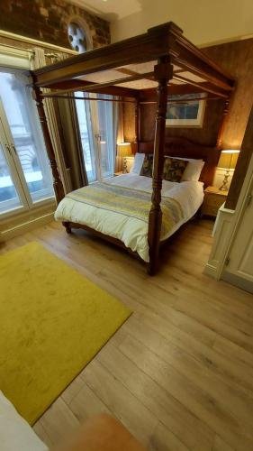 een slaapkamer met een hemelbed en een tapijt bij 43A Crown Street in Halifax
