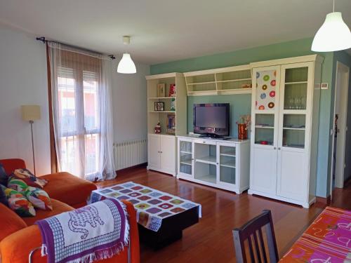 ein Wohnzimmer mit einem Sofa und einem TV in der Unterkunft Centro, garaje incluido, La casita de Nani, entre río y montañas wifi free in Ramales de la Victoria