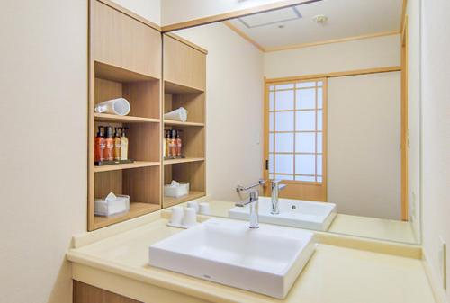 a bathroom with a sink and a mirror at Hamanoyu in Higashiizu