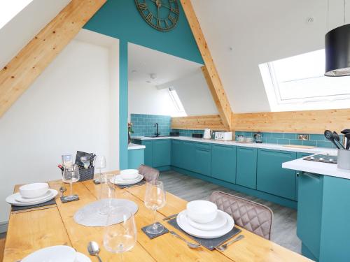 kuchnia z drewnianym stołem i niebieskimi szafkami w obiekcie Kerry Hill - The Sheepfold w mieście Llandrindod Wells