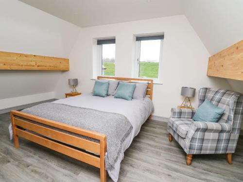 a bedroom with a bed and a chair at Kerry Hill - The Sheepfold in Llandrindod Wells