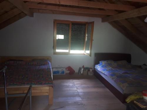 a bedroom with two beds and a window at House with big garden next to the mountain river in Kruševo