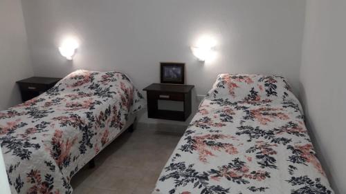 sypialnia z 2 łóżkami i 2 szafkami nocnymi w obiekcie Alojamiento Guemes w mieście Gualeguay