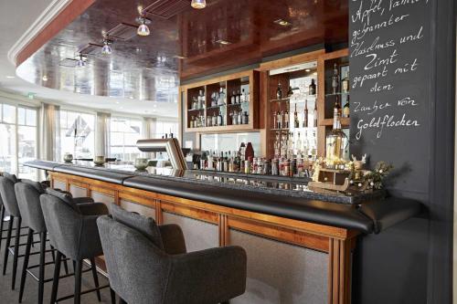 a bar with chairs and a counter with alcohol bottles at Hotel Rosenstock - Erwachsenenhotel - Adults only 15 plus in Fischen