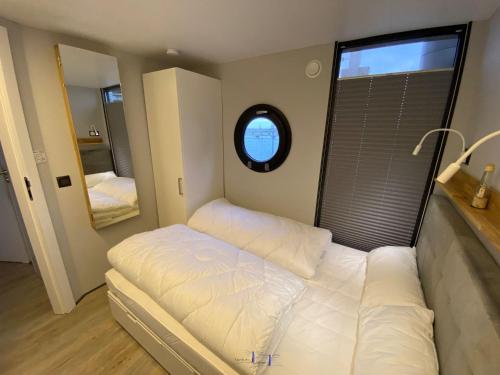 a small bedroom with a bed and a window at Hausboot Fjord Luna mit Biosauna in Wendtorf in Wendtorf