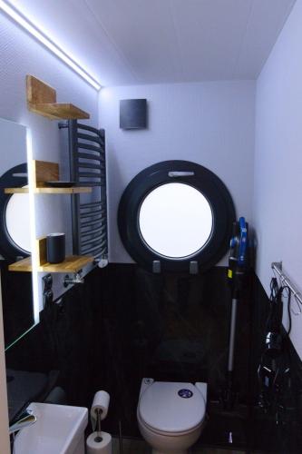 a bathroom with a toilet and a round window at Hausboot Fjord Luna mit Biosauna in Wendtorf in Wendtorf