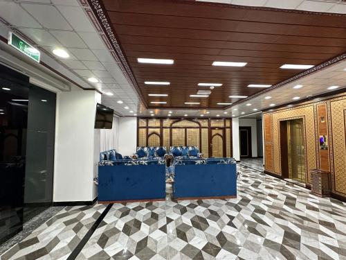 a large room with blue chairs on a checkered floor at AFAQ AL BATINAH - SAHAM in Şaḩam