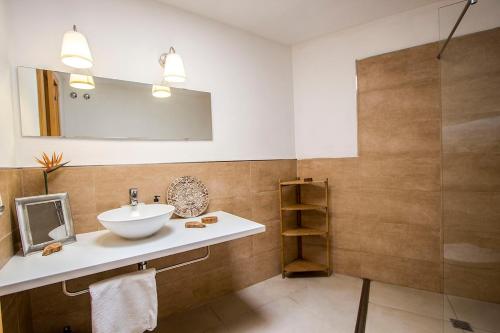 een badkamer met een wastafel en een douche bij Catalunya Casas Modern Magnificence , only a few km to the beach! in Sant Cebrià de Vallalta