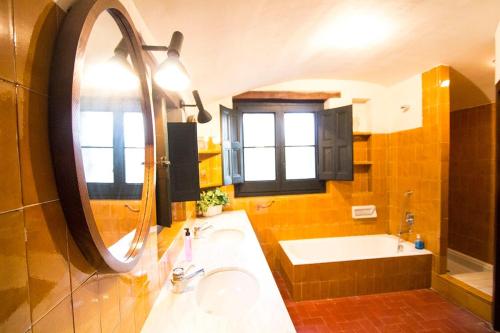 y baño con lavabo, espejo y bañera. en Catalunya Casas Heavenly Haven for 16 pax , 30km from Barcelona! en San Felíu del Racó