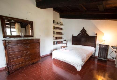 um quarto com uma cama e uma cómoda em madeira em Catalunya Casas Heavenly Haven for 16 pax , 30km from Barcelona! em San Felíu del Racó