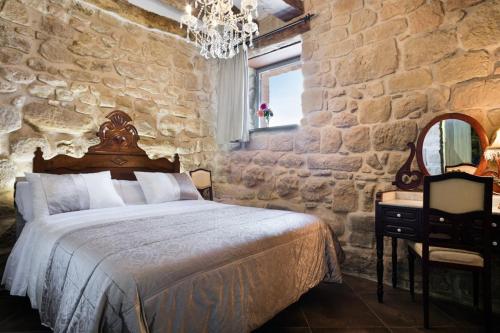 a stone walled bedroom with a bed and a mirror at Catalunya Casas Fabulous Villa for 28 with Heated Pool in Torá de Rulbregos