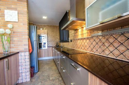 a kitchen with stainless steel appliances and a brick wall at Catalunya Casas Modern and spacious with private pool close to BCN in Senmanat