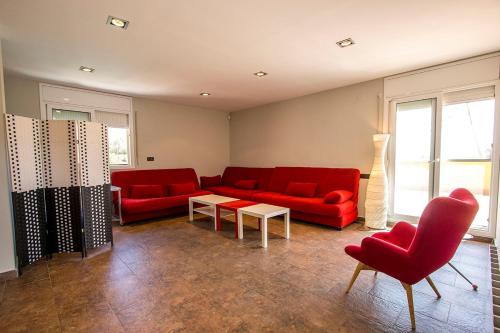 a living room with red couches and a table at Catalunya Casas Modern and spacious with private pool close to BCN in Senmanat