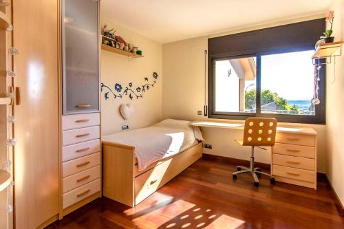 Un dormitorio con una cama y un escritorio y una ventana. en Catalunya Casas Stunning modern villa and just half hour to Barcelona!, en Caldes de Montbui