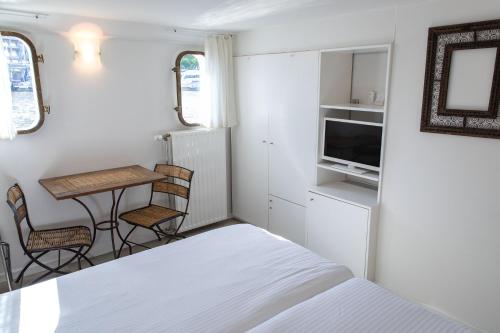 ein kleines Schlafzimmer mit einem Bett und einem Tisch und Stühlen in der Unterkunft Hotel The Boatel in Gent