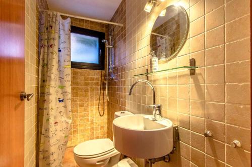 La salle de bains est pourvue d'un lavabo, de toilettes et d'un miroir. dans l'établissement Catalunya Casas Stunning modern villa and just half hour to Barcelona!, à Caldes de Montbui