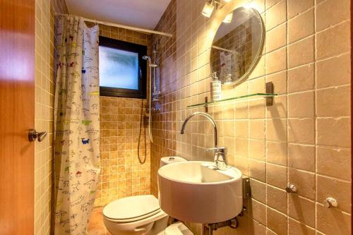 Un baño con lavabo, inodoro y espejo. en Catalunya Casas Stunning modern villa and just half hour to Barcelona!, en Caldes de Montbui