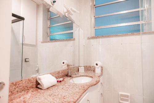 y baño con lavabo y espejo. en Apartamento confortável na quadra da praia, en Río de Janeiro