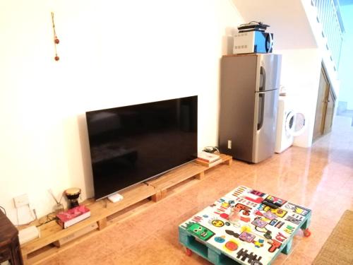 un soggiorno con una grande TV a schermo piatto di L'Ardenne Bleue Appartement a Rivière Noire