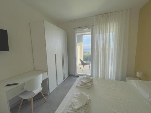 Un dormitorio con una cama y un escritorio y una ventana. en Villa Rubino, en Padenghe sul Garda