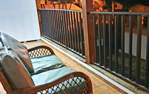 a bench sitting on a balcony with a fence at Royal-inn SPA & Pousada in Itanhaém
