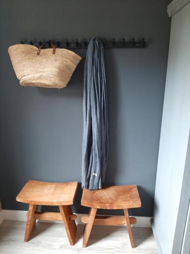 een kamer met 2 houten stoelen en een plank met een jas bij B&B De Verre Kijker in Barsingerhorn