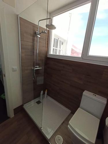 a bathroom with a glass shower and a toilet at ÁTICO SANTA MARÍA in Cádiz