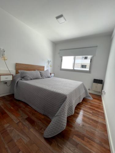 a bedroom with a large bed with a wooden floor at Temporario 48 in La Plata