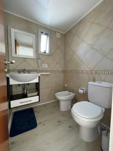 a bathroom with a white toilet and a sink at Temporario 48 in La Plata