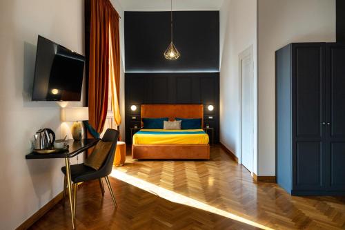 a bedroom with a bed and a desk and a television at La Lepre felice-bovio in Naples