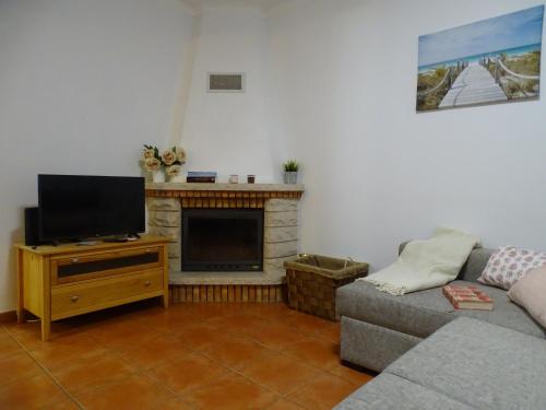 a living room with a couch and a flat screen tv at Lodge & Hike Almograve 2 in Almograve