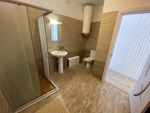 uma casa de banho com um chuveiro, um lavatório e um WC. em Family Hotel Rai-Only Adults em Golden Sands