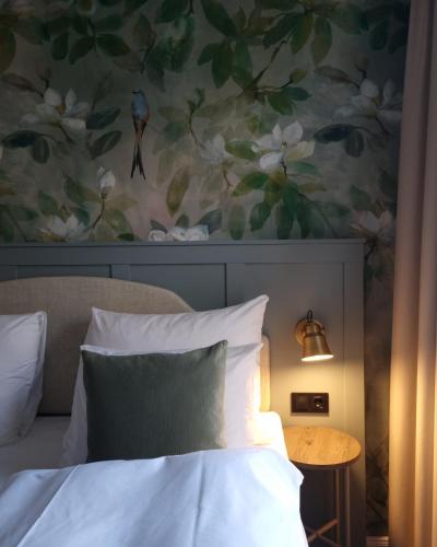a bedroom with a bed and a painting of flowers at Home Hotel Gabelshus in Oslo