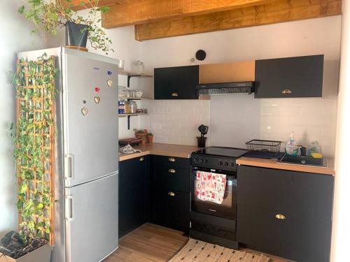 una cocina con refrigerador y estufa en Charmant petit appartement proche du pic St loup, en Le Triadou