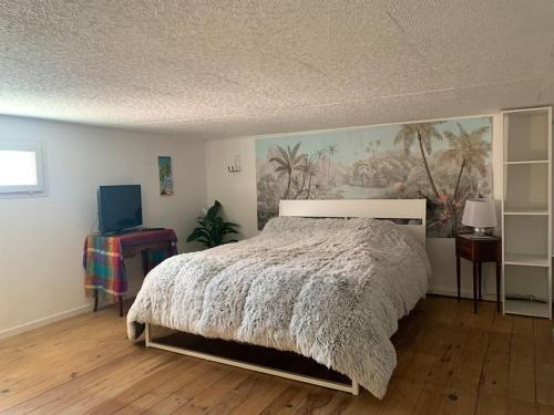 1 dormitorio con 1 cama y una pintura en la pared en Charmant petit appartement proche du pic St loup, en Le Triadou