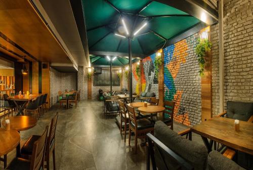 a restaurant with wooden tables and chairs and a brick wall at Hotel Bossuite Kadikoy in Istanbul